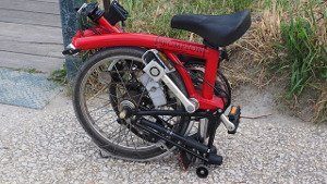 Ein rotes Klapprad zusammengefaltet.