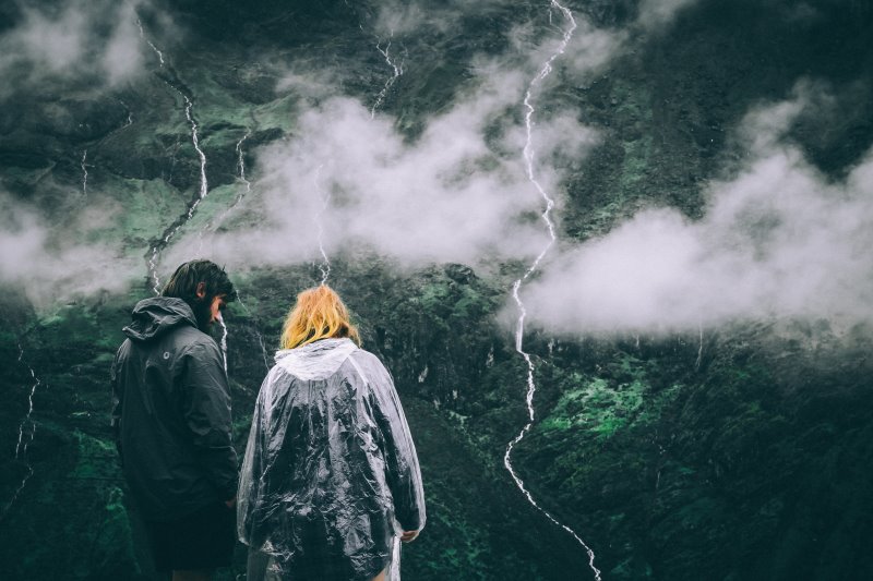 zwei Personen in Regenbekleidung, auf einem Berg