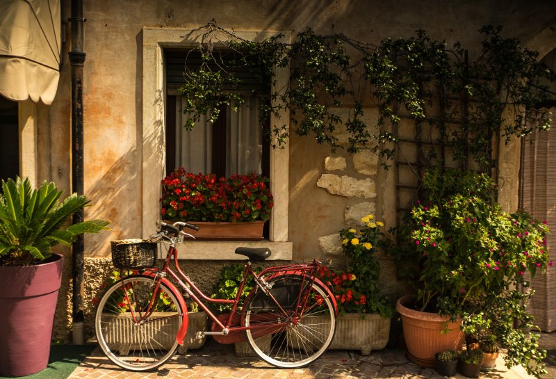 ein rotes Fahrrad lehnt an einer Hauswand